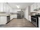 Bright kitchen with stainless steel appliances, granite counters, white cabinets, and wood-look flooring at 1876 Winding Creek Sw Ln, Marietta, GA 30064