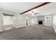 Spacious living room featuring a stone fireplace, plush carpeting, and a ceiling fan for added comfort at 1876 Winding Creek Sw Ln, Marietta, GA 30064