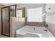 Bathroom featuring corner tub, glass-enclosed shower, and window for natural light at 3313 Alhambra Cir, Hampton, GA 30228