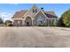 Clubhouse with brick and stone exterior, large windows, and ample parking space at 3313 Alhambra Cir, Hampton, GA 30228