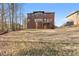 Rear exterior view of a brick home with a small wood deck overlooking the spacious backyard at 3313 Alhambra Cir, Hampton, GA 30228