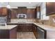 Well-equipped kitchen with stainless steel appliances, granite countertops, and dark brown cabinetry at 3313 Alhambra Cir, Hampton, GA 30228