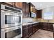 Modern kitchen featuring stainless steel double ovens, granite countertops, and tile backsplash at 3313 Alhambra Cir, Hampton, GA 30228