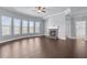 Spacious living room featuring a ceiling fan, a stone fireplace, and large windows at 3313 Alhambra Cir, Hampton, GA 30228