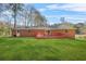 Well-maintained backyard with a red deck, lush green grass, and a brick house perfect for outdoor activities at 4218 Hideaway Dr, Tucker, GA 30084
