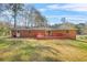 Well-maintained backyard with a red deck, lush green grass, and a brick house perfect for outdoor activities at 4218 Hideaway Dr, Tucker, GA 30084