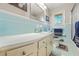 Vintage bathroom with light-blue tile, white sink, mirror, and a window with natural light at 4218 Hideaway Dr, Tucker, GA 30084