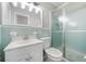 Small vintage bathroom with light-blue tile, a frosted glass shower door, and a white toilet and sink at 4218 Hideaway Dr, Tucker, GA 30084