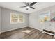 Sunlit bedroom with neutral walls, wood floors, and two large windows overlooking the outdoors at 4218 Hideaway Dr, Tucker, GA 30084