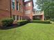 Brick house with manicured green lawn and landscaping with privacy hedges at 6205 Arnall Nw Ct, Acworth, GA 30101