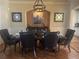 Dining room featuring dark wood table, chairs, decorative mirrors, a unique chandelier, and hardwood floors at 6205 Arnall Nw Ct, Acworth, GA 30101