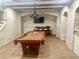 A game room with a pool table, bar seating, accent brick walls and stairs to another level at 6205 Arnall Nw Ct, Acworth, GA 30101