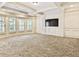 Living room with neutral carpet, coffered ceiling, and built-in cabinets with a large TV at 6205 Arnall Nw Ct, Acworth, GA 30101