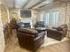 A living room with leather seating, wood floors, white brick walls and a fireplace under a TV at 6205 Arnall Nw Ct, Acworth, GA 30101