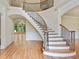 Grand foyer showcasing a curved staircase with wrought iron spindles, hardwood floors and decorative trim at 6205 Arnall Nw Ct, Acworth, GA 30101