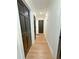 Hallway with hardwood floors, white walls, and contrasting black doors creating a modern and elegant aesthetic at 152 Weatherstone Pkwy, Marietta, GA 30068