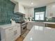 Modern kitchen with white cabinets, stainless steel appliances, quartz countertops, and green tile backsplash at 152 Weatherstone Pkwy, Marietta, GA 30068