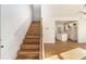 Bright hallway featuring hardwood floors, staircase with white railings, and view of the modern kitchen at 2058 Detroit Nw Ave, Atlanta, GA 30314