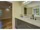 Bathroom showcasing a double vanity with marble countertops and modern fixtures, next to a sunlit bedroom at 2436 Green Hollow Ct, Conyers, GA 30012