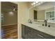 Bathroom featuring double sinks, granite countertops, with wood flooring, and decorative mirror at 2436 Green Hollow Ct, Conyers, GA 30012