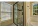 Bathroom featuring tiled shower, a tub, a window and great natural light at 2436 Green Hollow Ct, Conyers, GA 30012