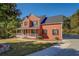 Charming two-story brick home features a covered porch, mature trees, and a well-manicured lawn at 2436 Green Hollow Ct, Conyers, GA 30012