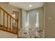 Bright foyer featuring decorative tile flooring, a wooden staircase, and a welcoming front door at 2436 Green Hollow Ct, Conyers, GA 30012