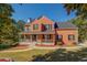 Charming two-story red brick home with a welcoming front porch and beautifully landscaped yard at 2436 Green Hollow Ct, Conyers, GA 30012