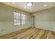 Bright living room boasts hardwood floors, decorative molding, and a large window with wooden blinds at 2436 Green Hollow Ct, Conyers, GA 30012