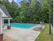 Outdoor pool area with loungers, a diving board, and a tall green tree line at 2436 Green Hollow Ct, Conyers, GA 30012