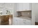 Butler's pantry with sink, granite countertops, white cabinets, and herringbone backsplash at 2517 Canopy Ct, Marietta, GA 30066