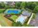 Aerial view of a neighborhood swimming pool, tennis court, and playground surrounded by lush landscaping and mature trees at 2517 Canopy Ct, Marietta, GA 30066