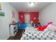 Cozy bedroom featuring two twin beds with lively decor and a cheerful red accent wall at 275 Fern Crest Dr, Lawrenceville, GA 30046