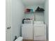 A compact laundry room with washer, dryer, and overhead shelving for supplies at 275 Fern Crest Dr, Lawrenceville, GA 30046