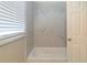 Bathroom featuring marble style tiled walls above a white tub at 3716 Loren Dr, Decatur, GA 30032