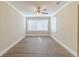 An empty room featuring wood floors, a ceiling fan, a large window, and neutral wall paint at 3716 Loren Dr, Decatur, GA 30032