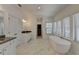 Spacious bathroom with double vanities, soaking tub, marble floors, and natural light at 3856 Allegretto Cir, Atlanta, GA 30339