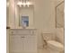 Bathroom featuring a white cabinet, toilet, mirror, and tiled shower with glass door at 3856 Allegretto Cir, Atlanta, GA 30339