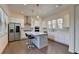 Bright, white kitchen with stainless steel appliances, island with seating, and hardwood floors at 3856 Allegretto Cir, Atlanta, GA 30339