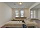 Inviting living room with a large sectional sofa, an ottoman, and natural light filtering through the window blinds at 3856 Allegretto Cir, Atlanta, GA 30339