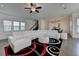 Cozy living room featuring hardwood floors, modern ceiling fan, and spiral patterned area rug at 3856 Allegretto Cir, Atlanta, GA 30339