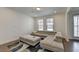 Bright living room featuring a comfortable sectional sofa, a large ottoman, and natural light from two windows at 3856 Allegretto Cir, Atlanta, GA 30339