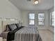 Bright main bedroom with a queen bed, two windows, and plush carpeting at 3856 Allegretto Cir, Atlanta, GA 30339