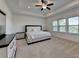 Spacious main bedroom with ceiling fan, tray ceiling, carpet, and large windows allowing natural light at 3856 Allegretto Cir, Atlanta, GA 30339