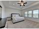 Spacious main bedroom with ceiling fan, tray ceiling, carpet, and large windows allowing natural light at 3856 Allegretto Cir, Atlanta, GA 30339