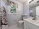 Bathroom with a tree-themed shower curtain, a white vanity, and a window letting in natural light at 6507 Bennington Dr, Tucker, GA 30084