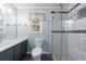 A beautifully tiled bathroom featuring a glass shower with a white vanity and a modern color scheme at 6507 Bennington Dr, Tucker, GA 30084