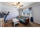 Bedroom featuring a futon and a ceiling fan in a well-lit space with a window and neutral walls at 6507 Bennington Dr, Tucker, GA 30084