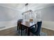 Elegant dining room with wood table, modern light fixture, and shuttered window at 6507 Bennington Dr, Tucker, GA 30084