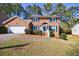 Charming two-story brick home with blue shutters, manicured landscaping, and attached two-car garage at 6507 Bennington Dr, Tucker, GA 30084